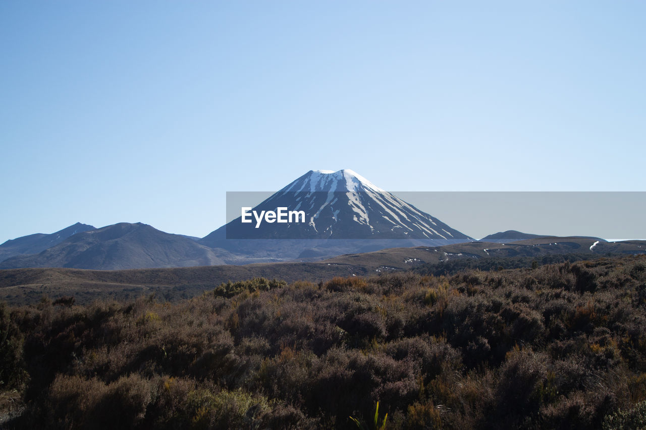 mountain, volcano, landscape, sky, scenics - nature, environment, beauty in nature, stratovolcano, nature, wilderness, travel destinations, land, no people, non-urban scene, snow, volcanic landscape, travel, clear sky, geology, mountain peak, blue, tranquil scene, snowcapped mountain, winter, cold temperature, tranquility, cinder cone, plant, ridge, tourism, outdoors, day, culture, plateau, copy space, natural environment, sunny, idyllic