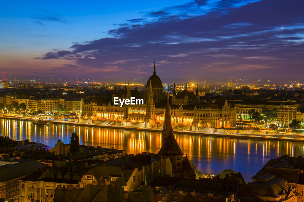 Illuminated hungarian parliament building and cityscape against sky at night