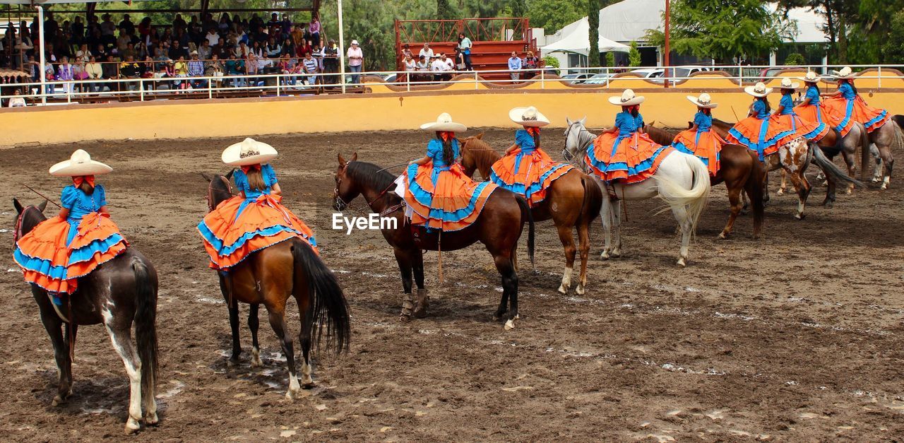 Women riding horses during charreada event