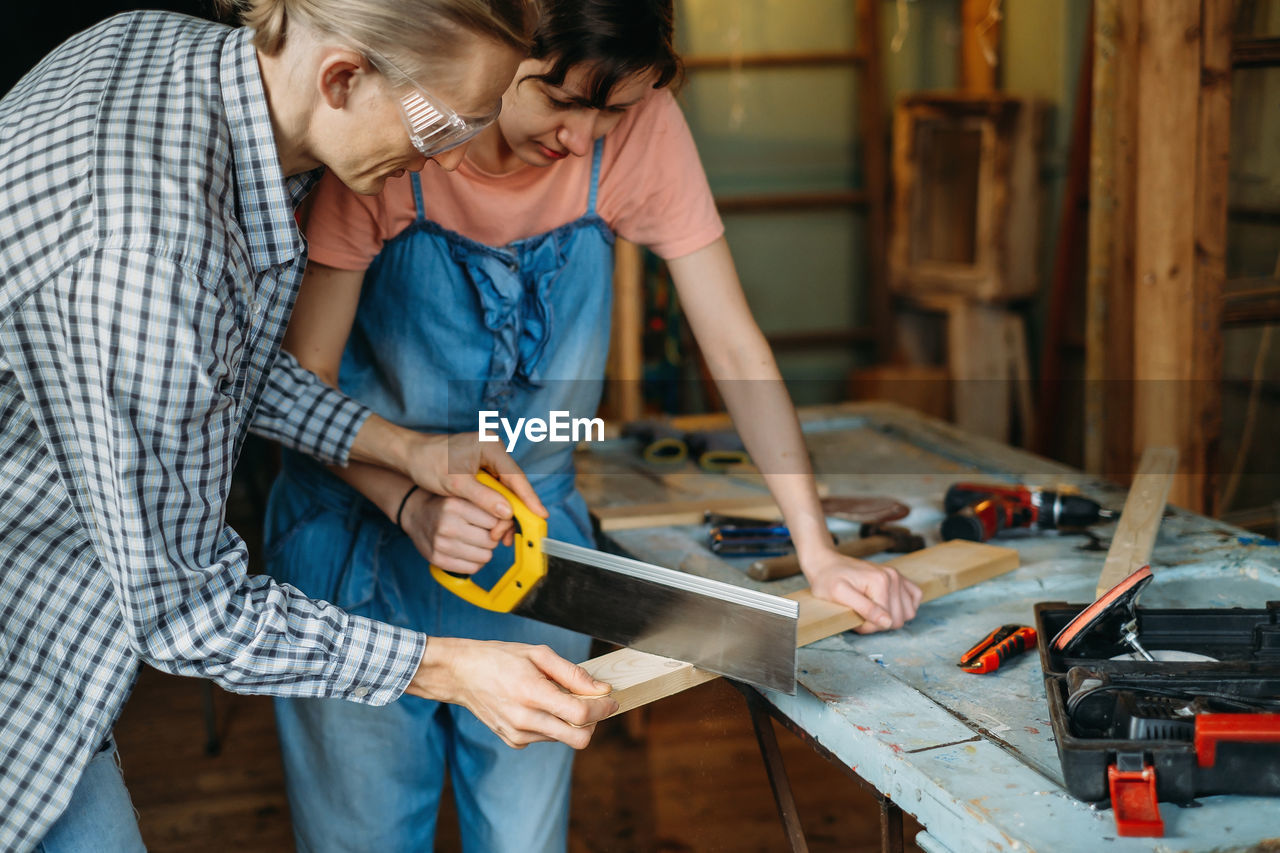 Man and woman working in workshop, doing furniture, reuse old materials to new product. awareness in