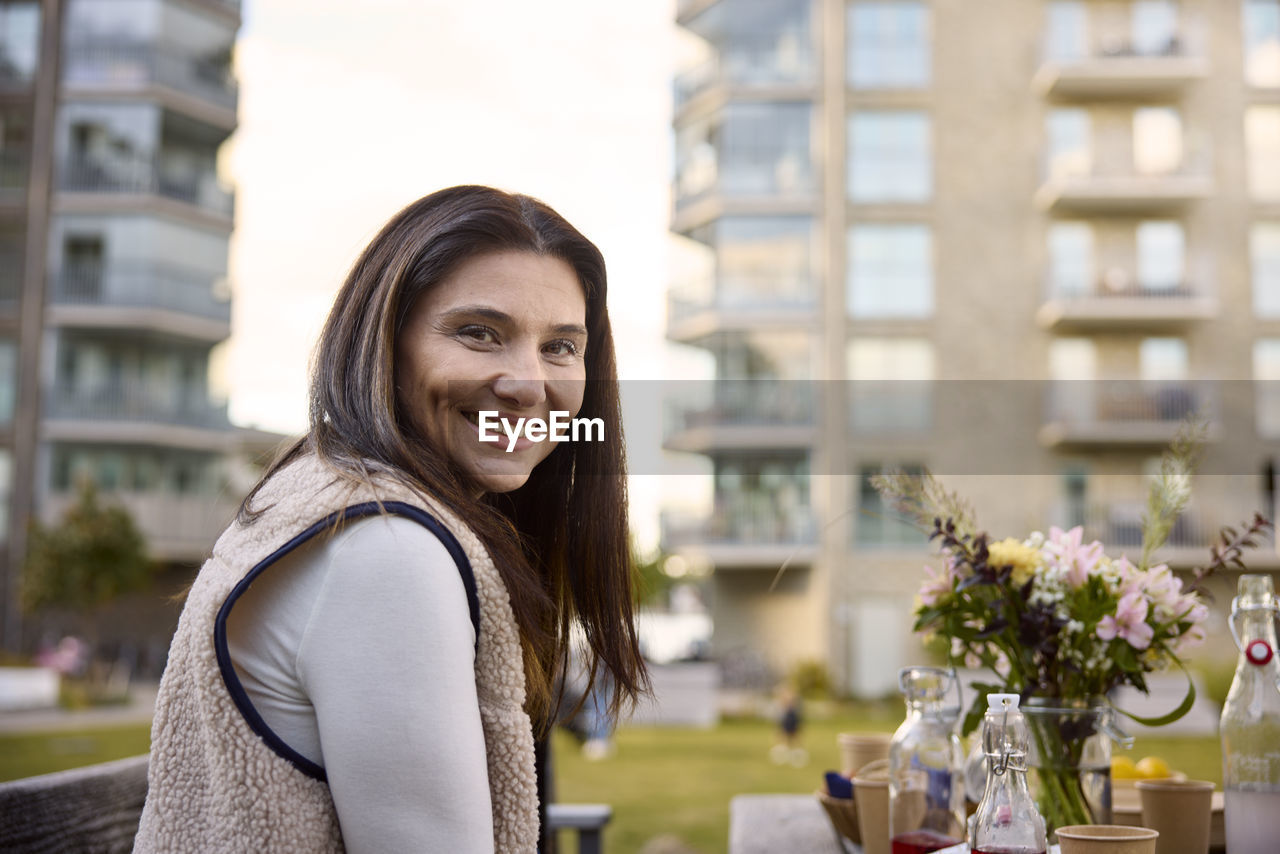 Smiling woman at table looking at camera