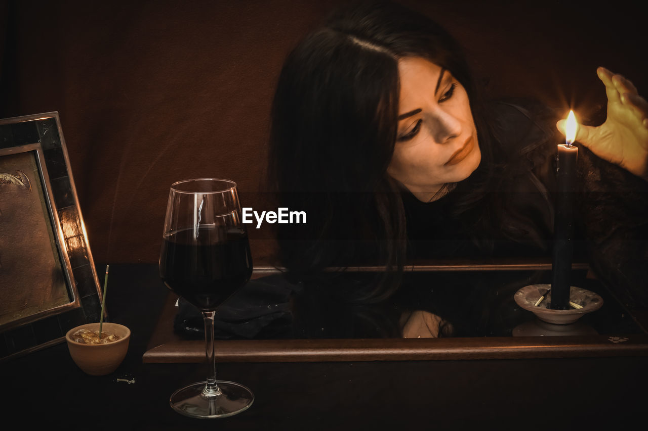 Close-up of woman with red wine on table during wiccan ritual 