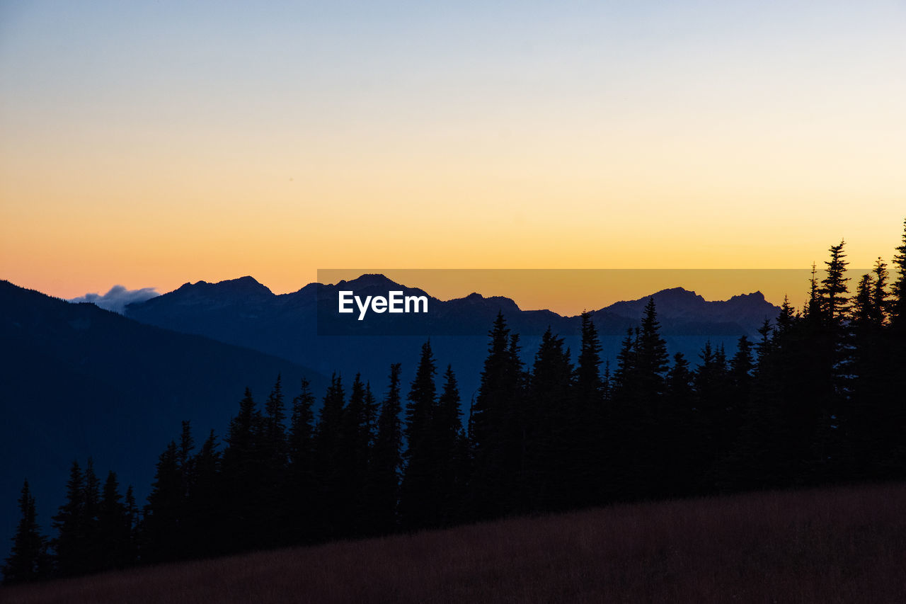 Scenic view of silhouette mountains against sky at sunset