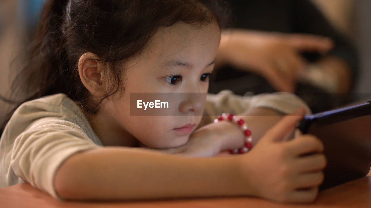 PORTRAIT OF CUTE GIRL LYING DOWN ON FLOOR