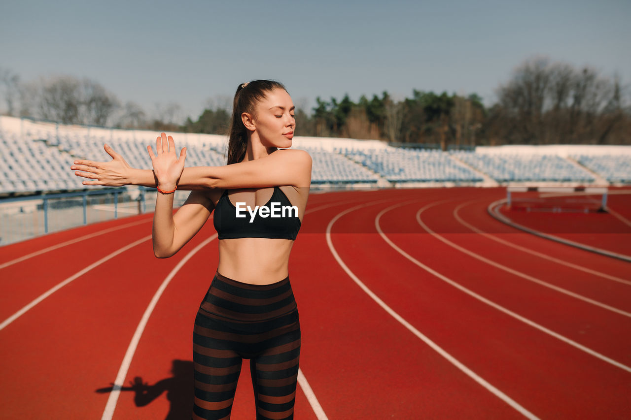 Portrait of female athlete exercising on running track