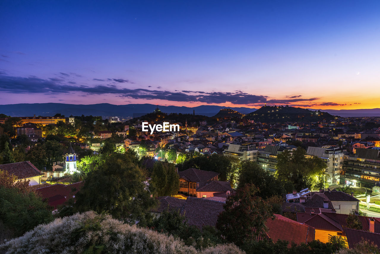 High angle view of illuminated buildings against sky at sunset