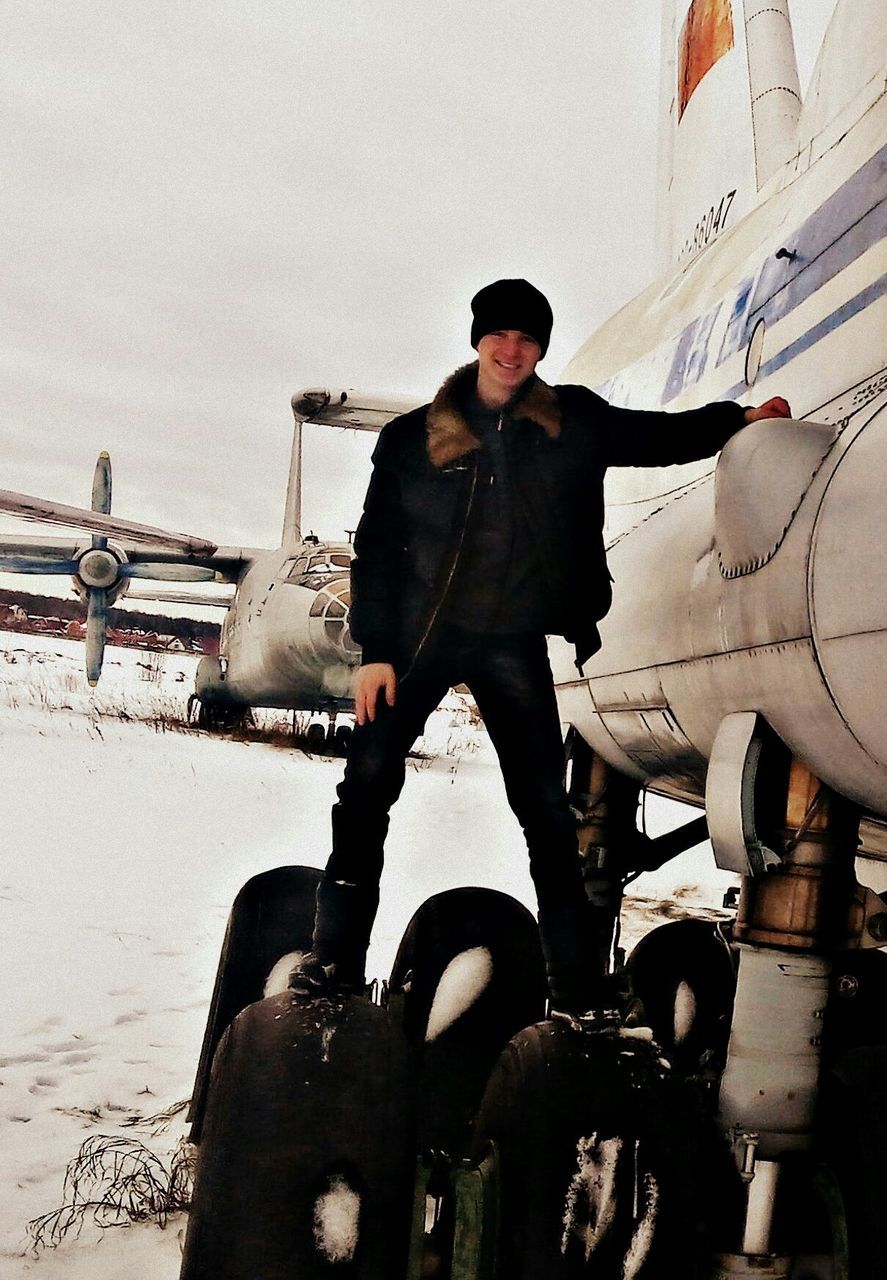 FULL LENGTH OF MAN STANDING ON VEHICLE AGAINST SKY