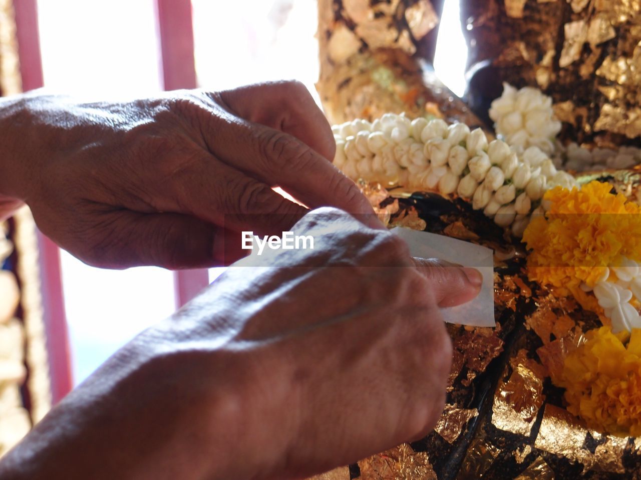 Cropped image of hands performing rituals at buddhist temple