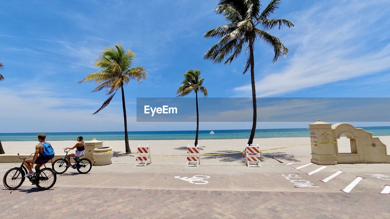 PEOPLE ON BEACH AGAINST SKY