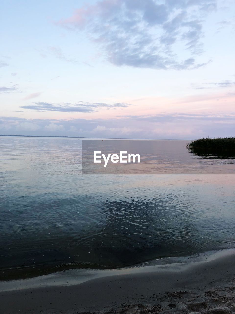 SCENIC VIEW OF BEACH AGAINST SKY AT SUNSET