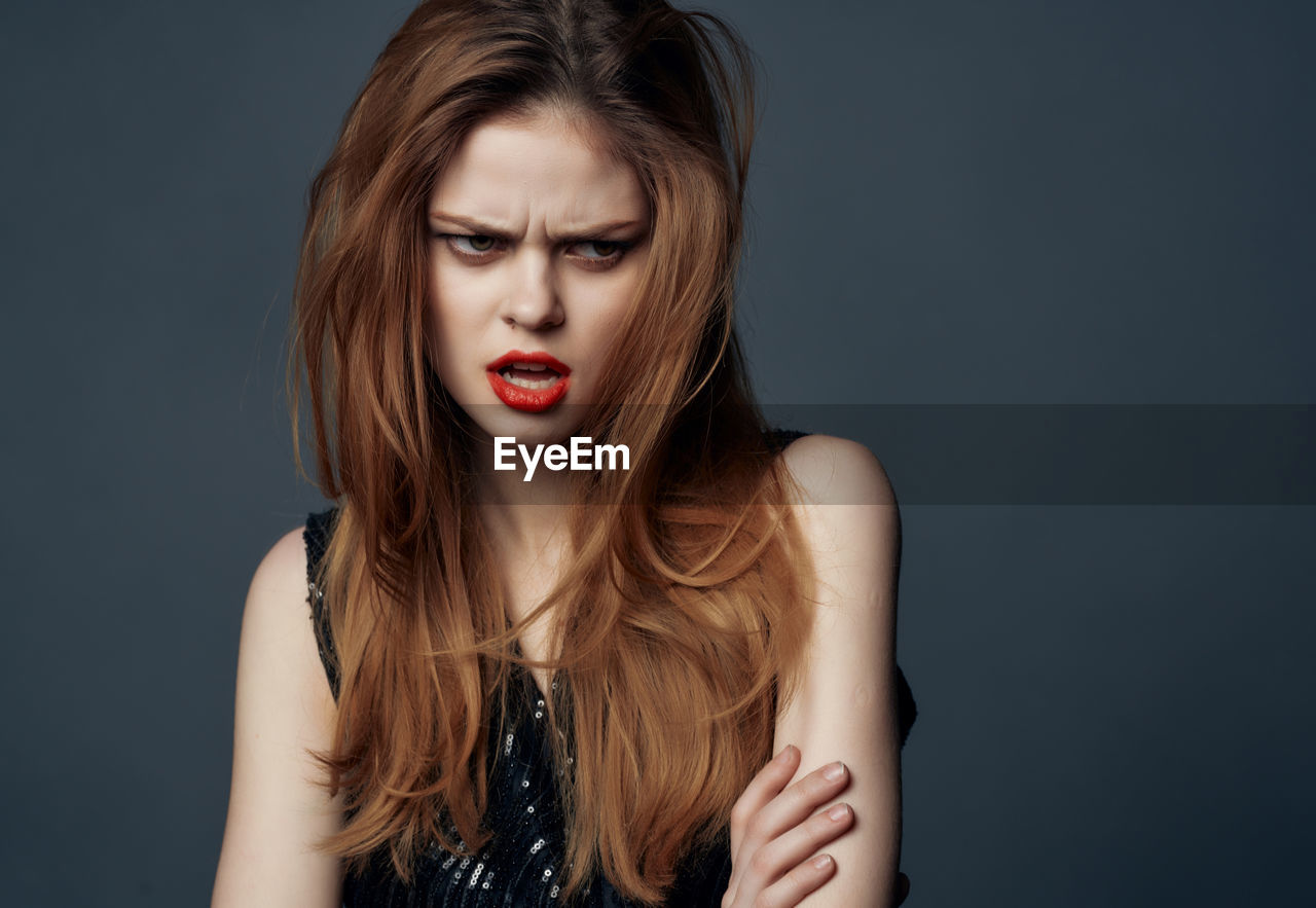 Portrait of beautiful young woman over black background