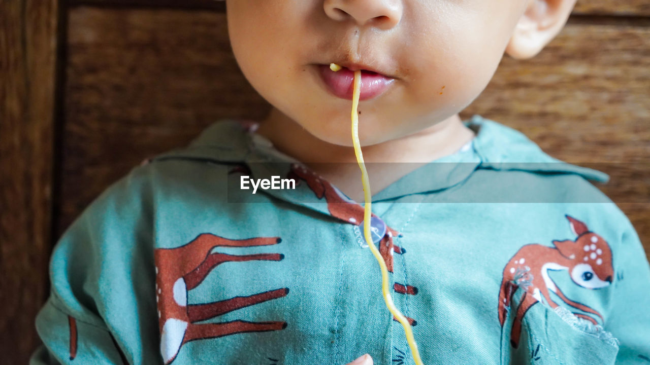 Close-up of boy eating noodles