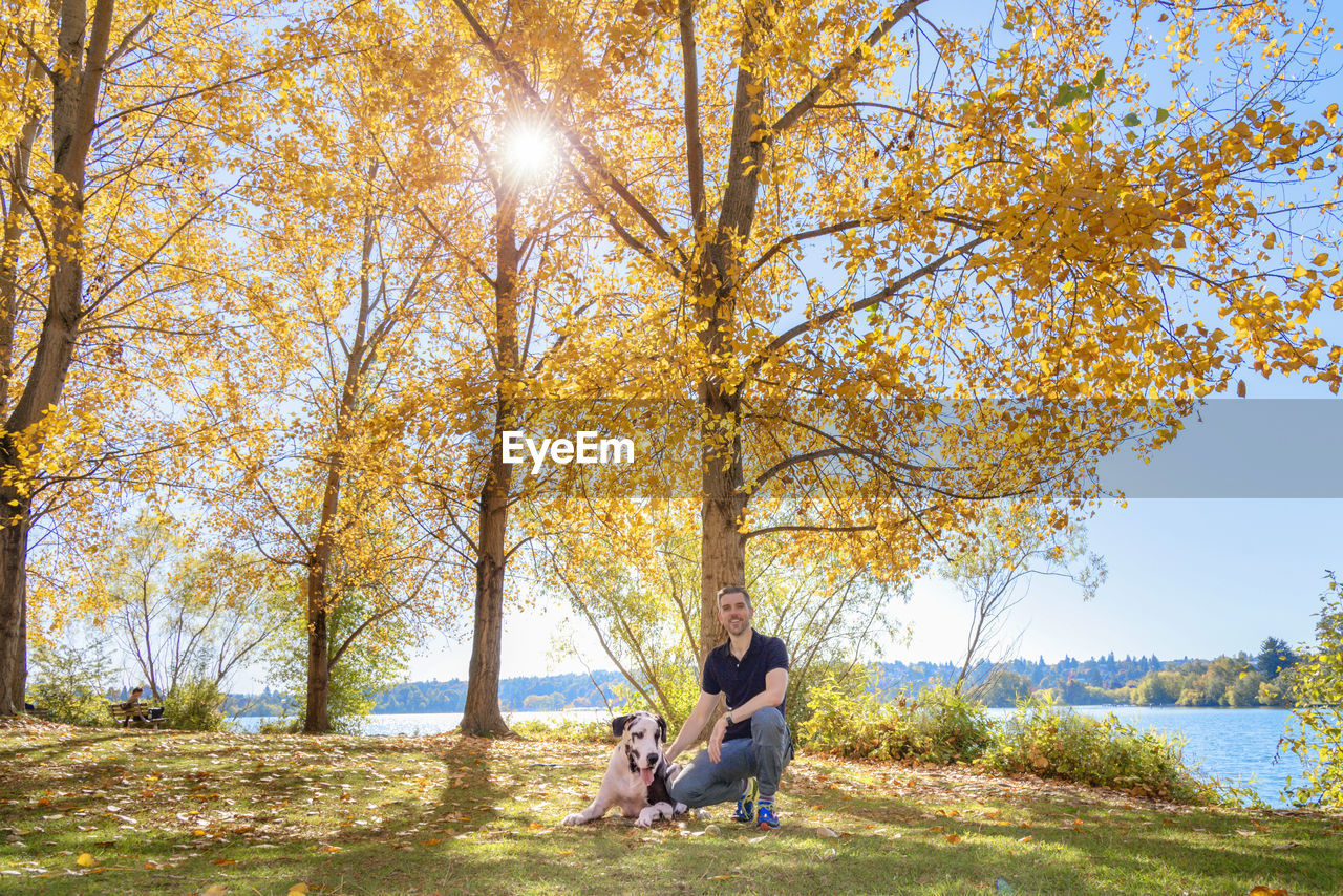 Full length of man with dog on field during autumn