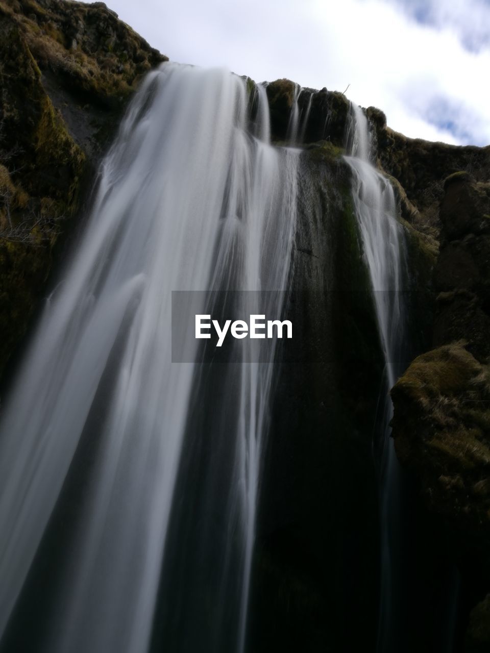 Low angle view of waterfall against sky