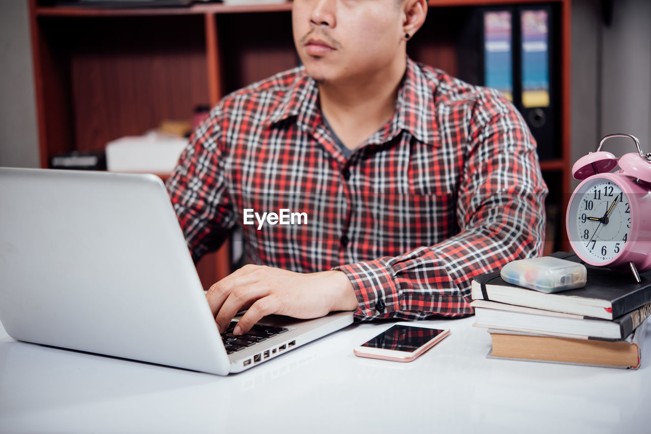 LOW ANGLE VIEW OF MAN USING SMART PHONE