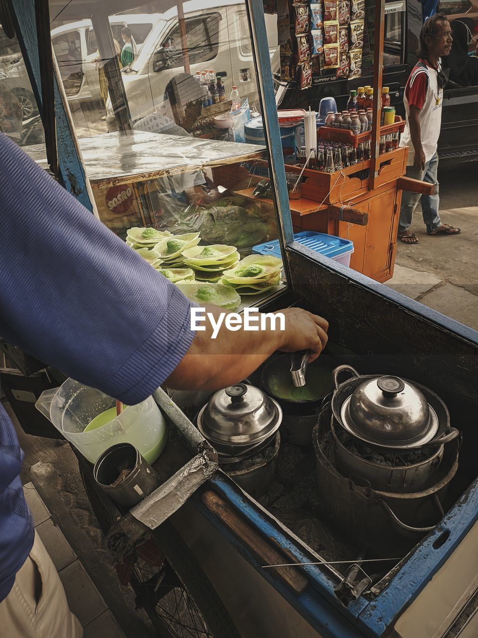 Midsection of worker preparing food at market stall