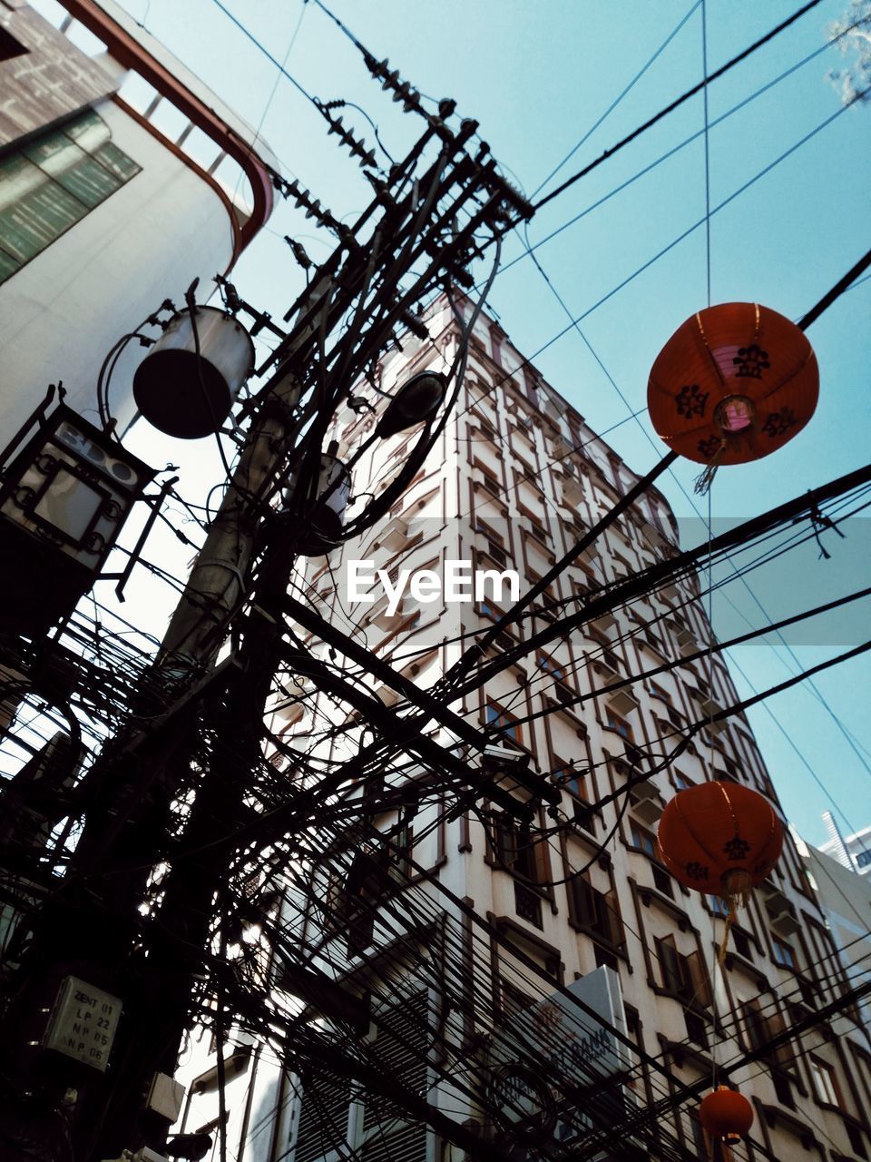 LOW ANGLE VIEW OF LANTERNS HANGING IN BUILDING AGAINST SKY