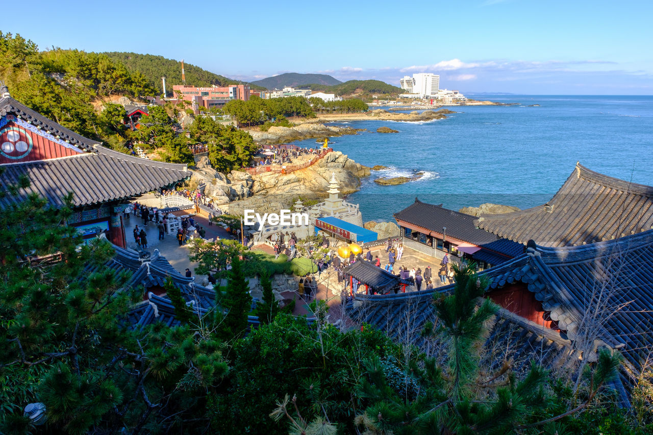 HIGH ANGLE VIEW OF BUILDINGS BY SEA AGAINST SKY