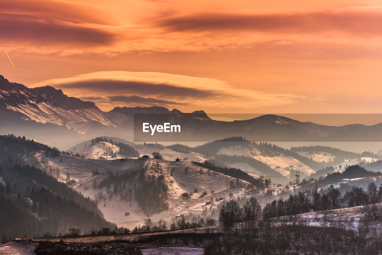 Scenic view of snowcapped mountains against sky during sunset