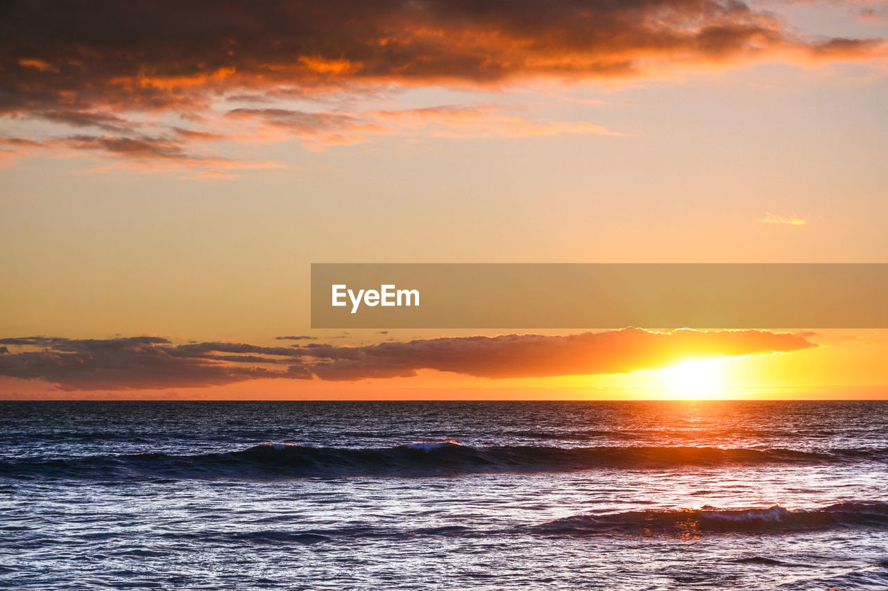 SCENIC VIEW OF SEA AGAINST ORANGE SKY DURING SUNSET