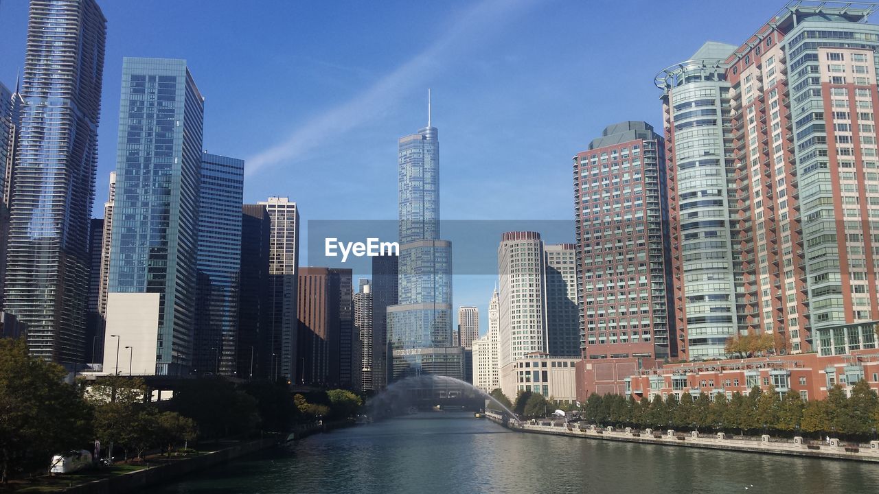 Chicago river amidst buildings against blue sky