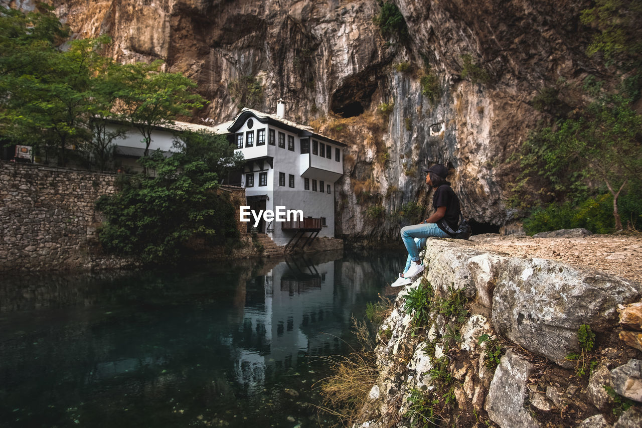 REFLECTION OF HOUSES AND ROCKS IN WATER BY BUILDINGS