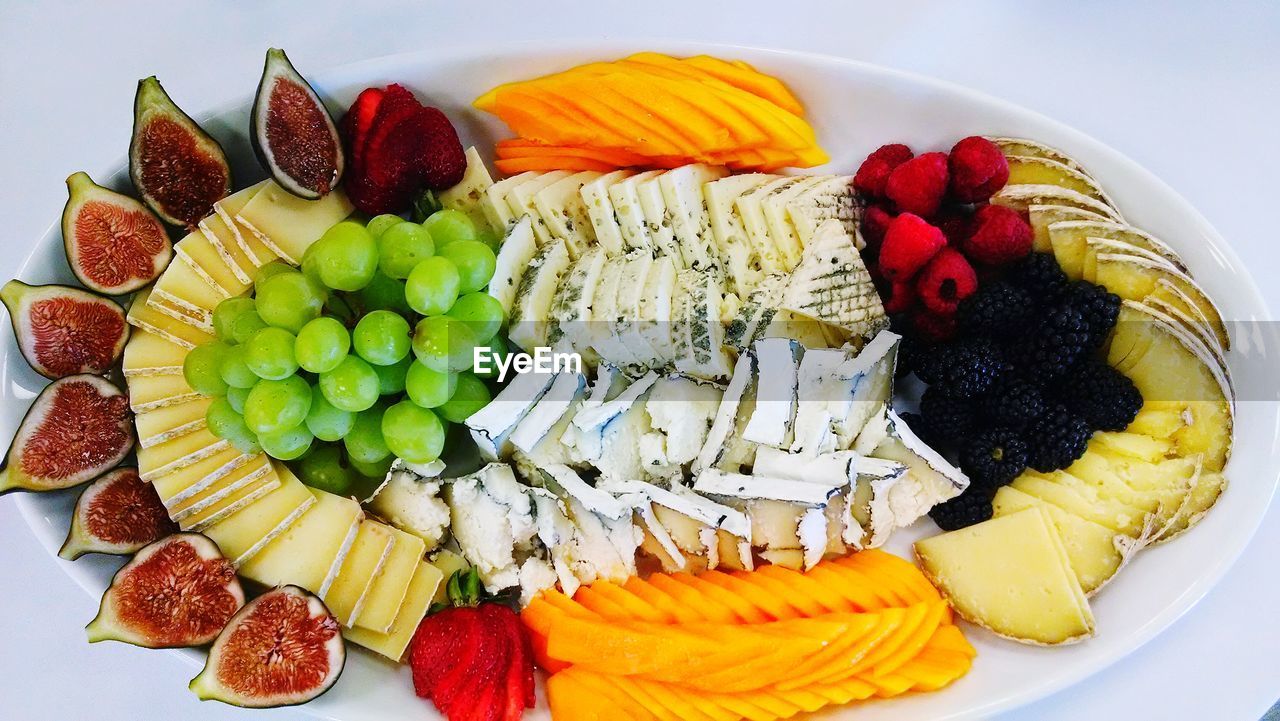 High angle view of fruits served in plate against white background