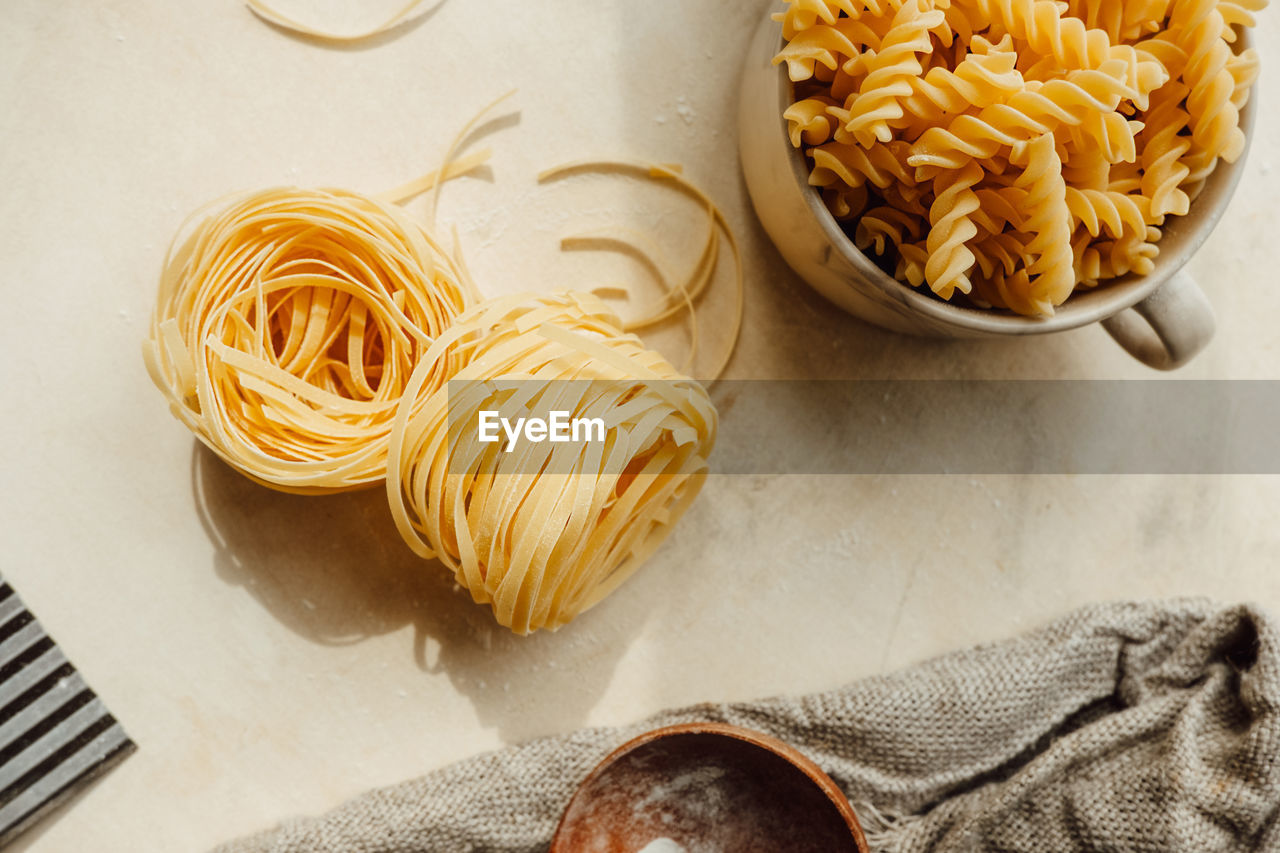 Raw tortiglioni pasta on background in cup. process of making hand-made pasta from durum wheat