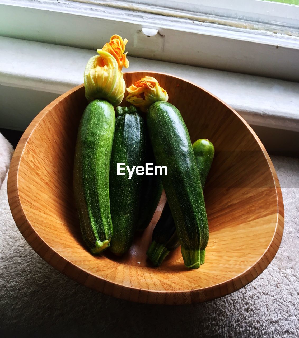 High angle view of zucchini in bowl by window
