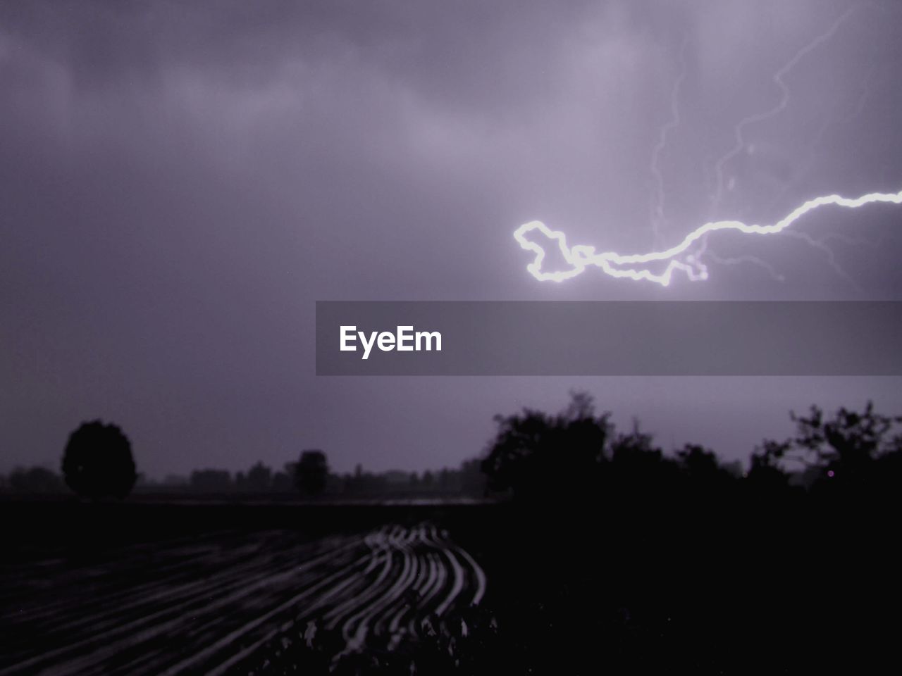 SCENIC VIEW OF LIGHTNING OVER FIELD