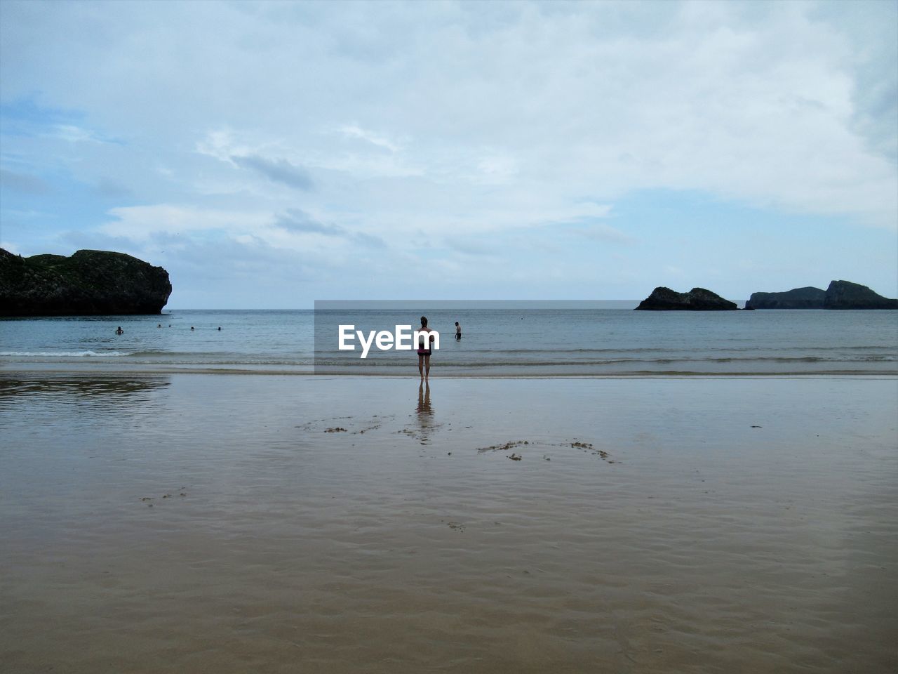 MAN STANDING AT BEACH AGAINST SKY