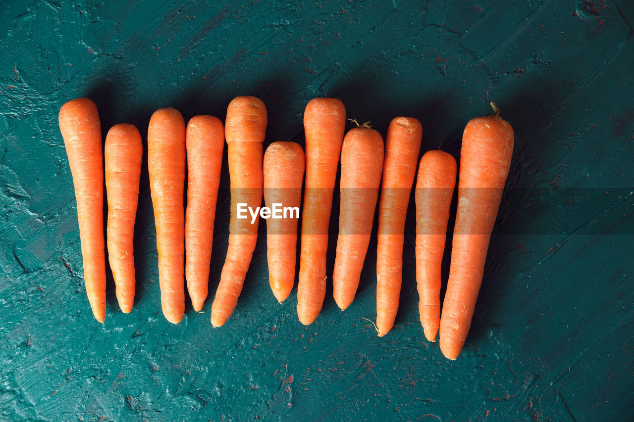 Several orange carrots on a green background