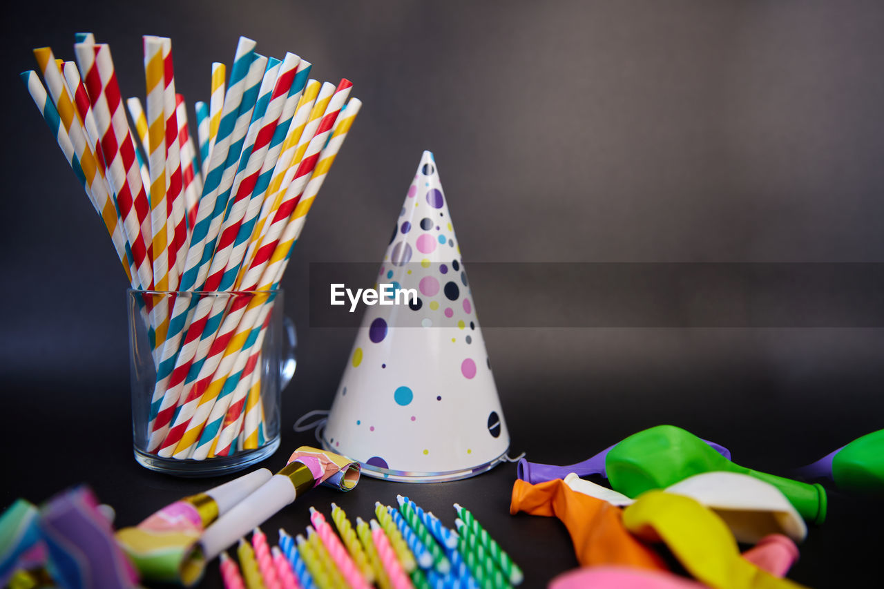 Happy birthday or party background. flat lay wtih birthday hats, confetti and ribbons . top view.