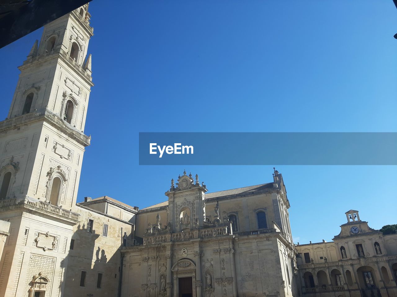 LOW ANGLE VIEW OF BUILDINGS AGAINST BLUE SKY