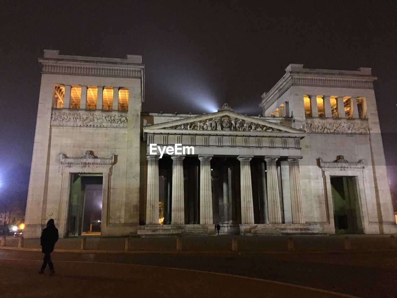 Rear view of man walking by koenigsplatz at night