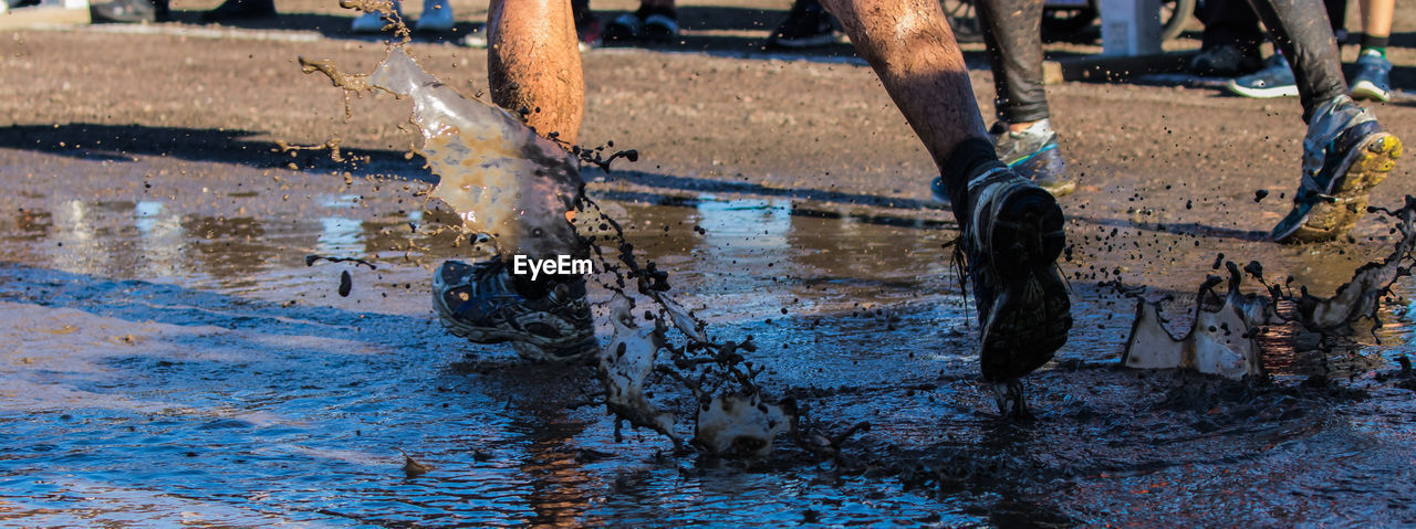 Low section of people running in puddle