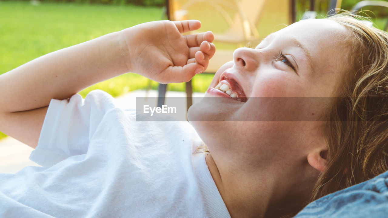 Close-up smiling boy lying outdoors