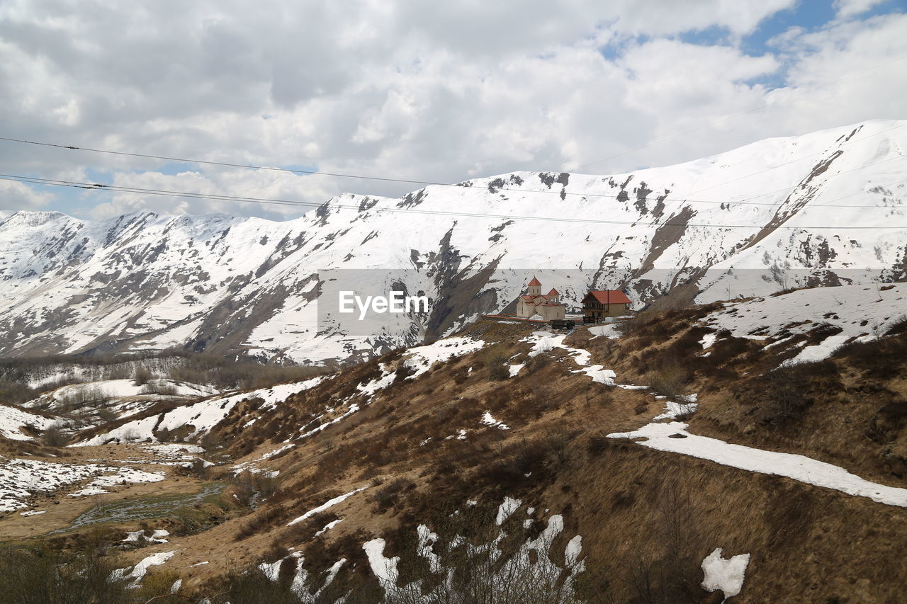 AERIAL VIEW OF SNOWCAPPED MOUNTAIN AGAINST SKY