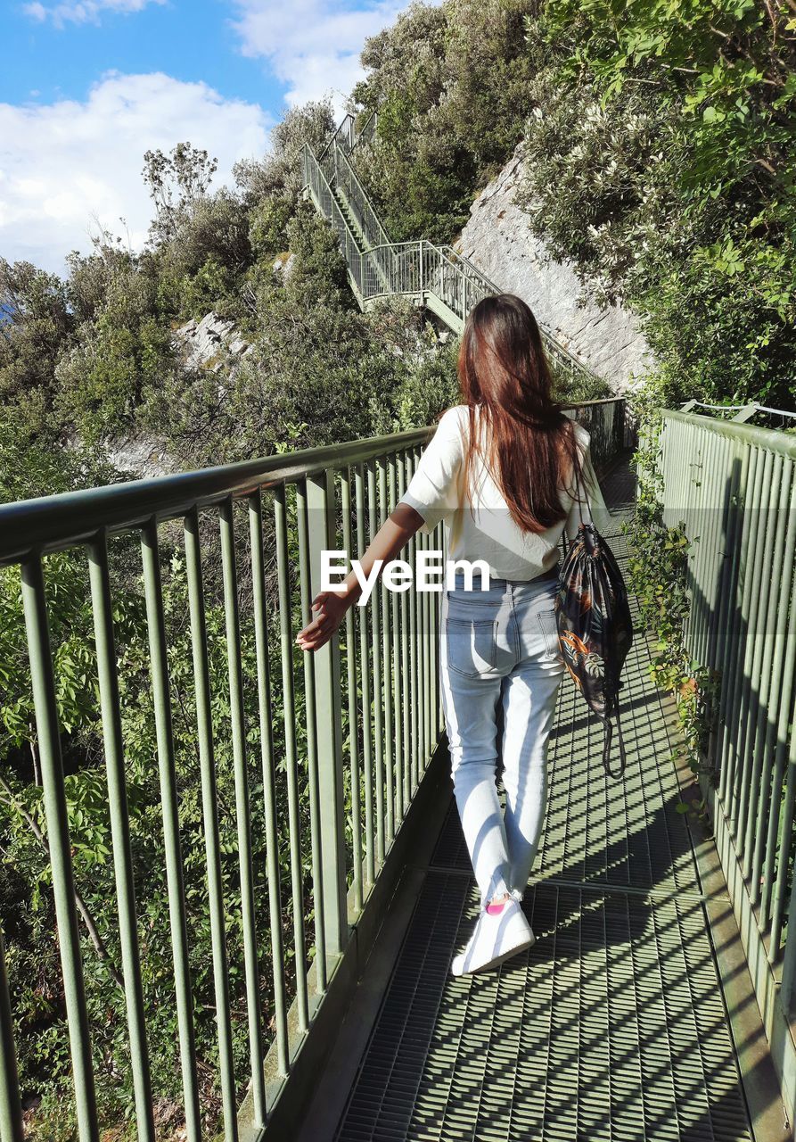 Girl walking on the bridge, bridge on the mountains