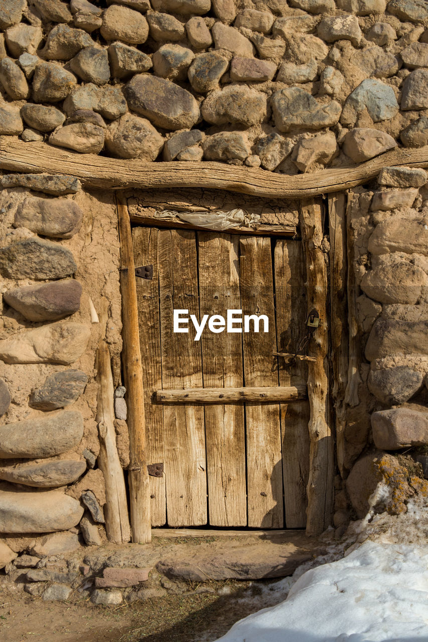 OLD WOODEN DOOR ON STONE WALL