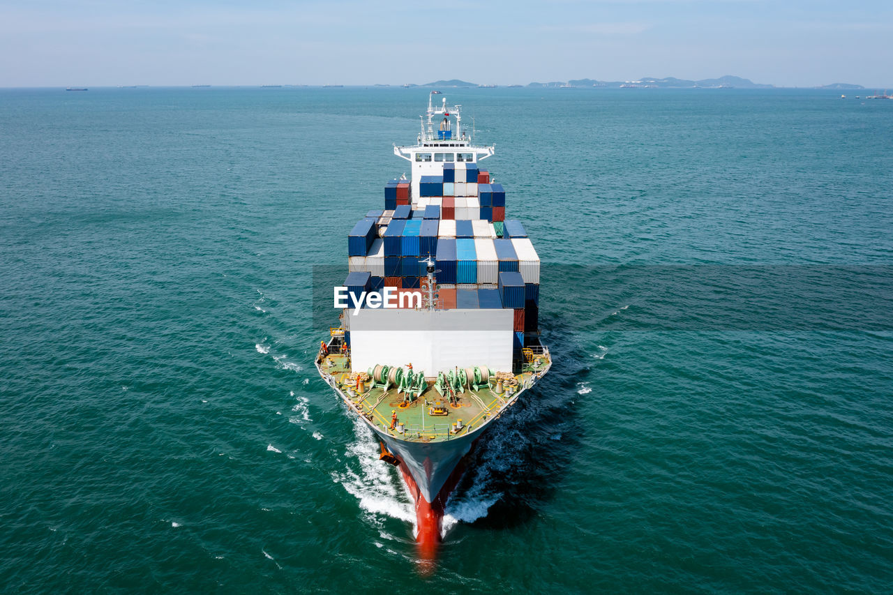 Container cargo ship carrying commercial container in import export business services commerce 