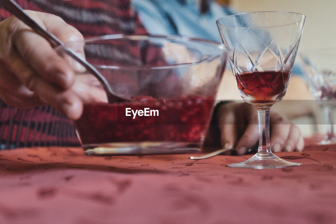 Midsection of man drinking wine at restaurant