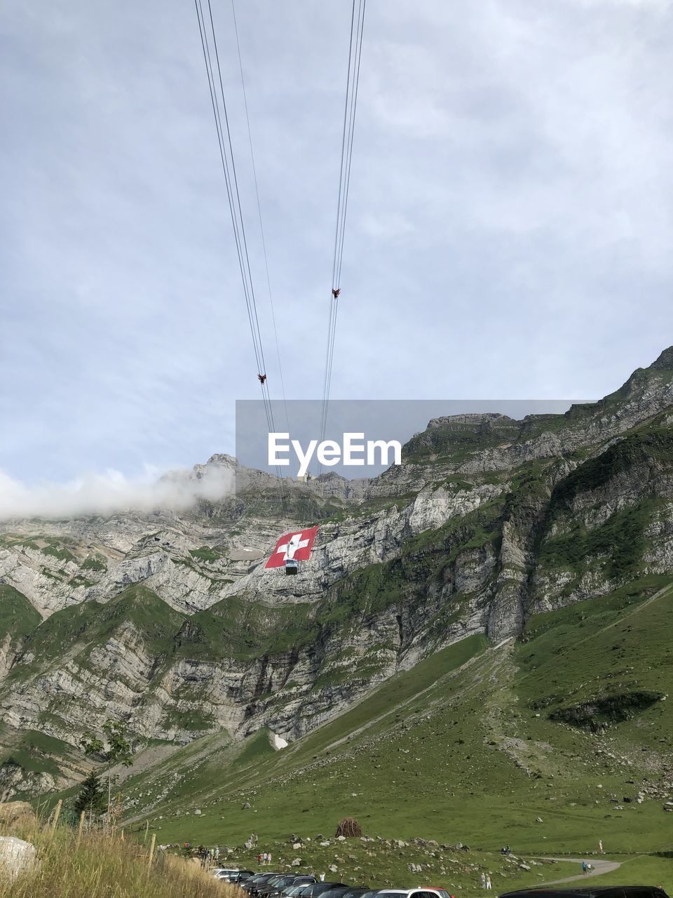 OVERHEAD CABLE CARS OVER MOUNTAIN AGAINST SKY