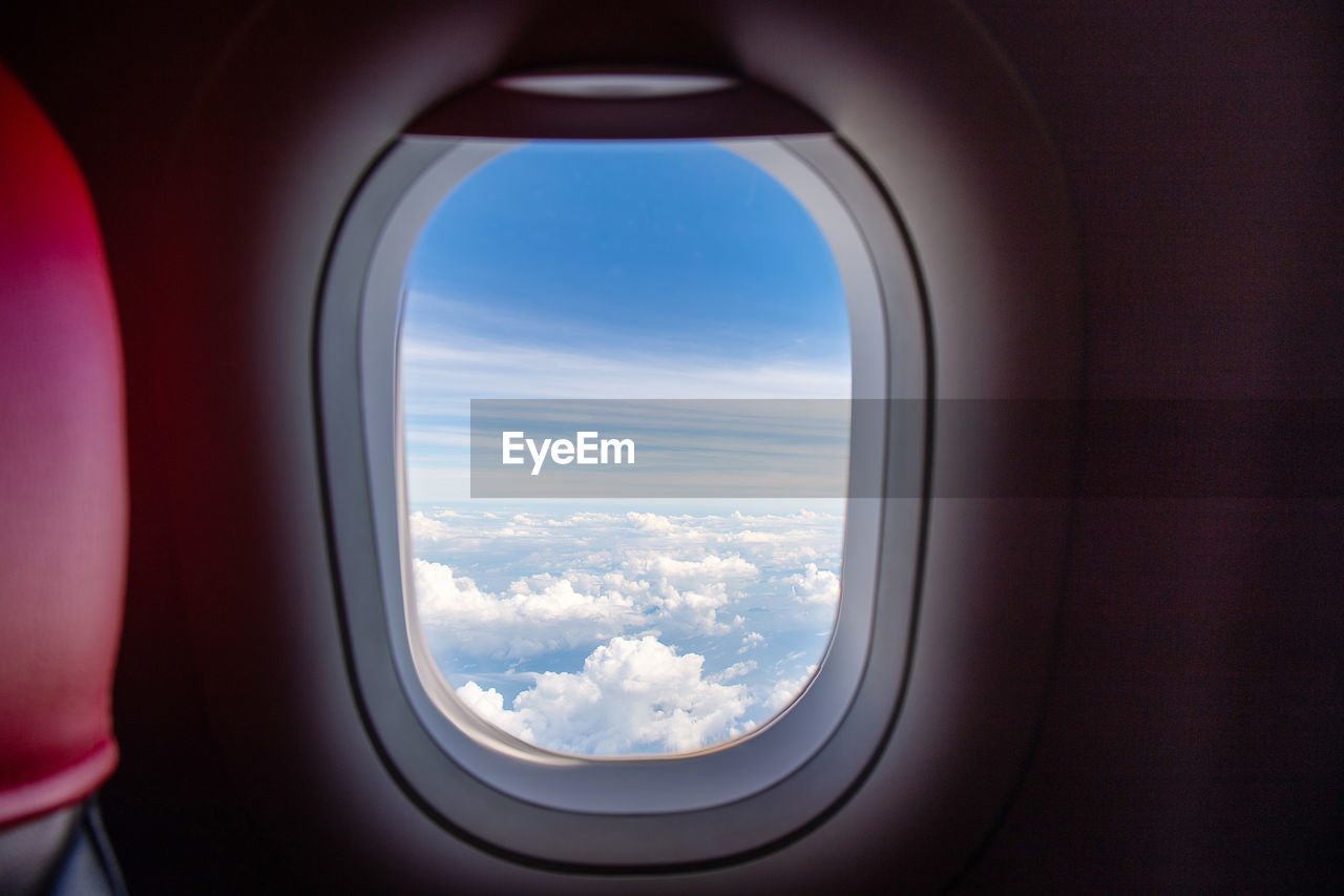 View of cloudy sky seen through airplane window