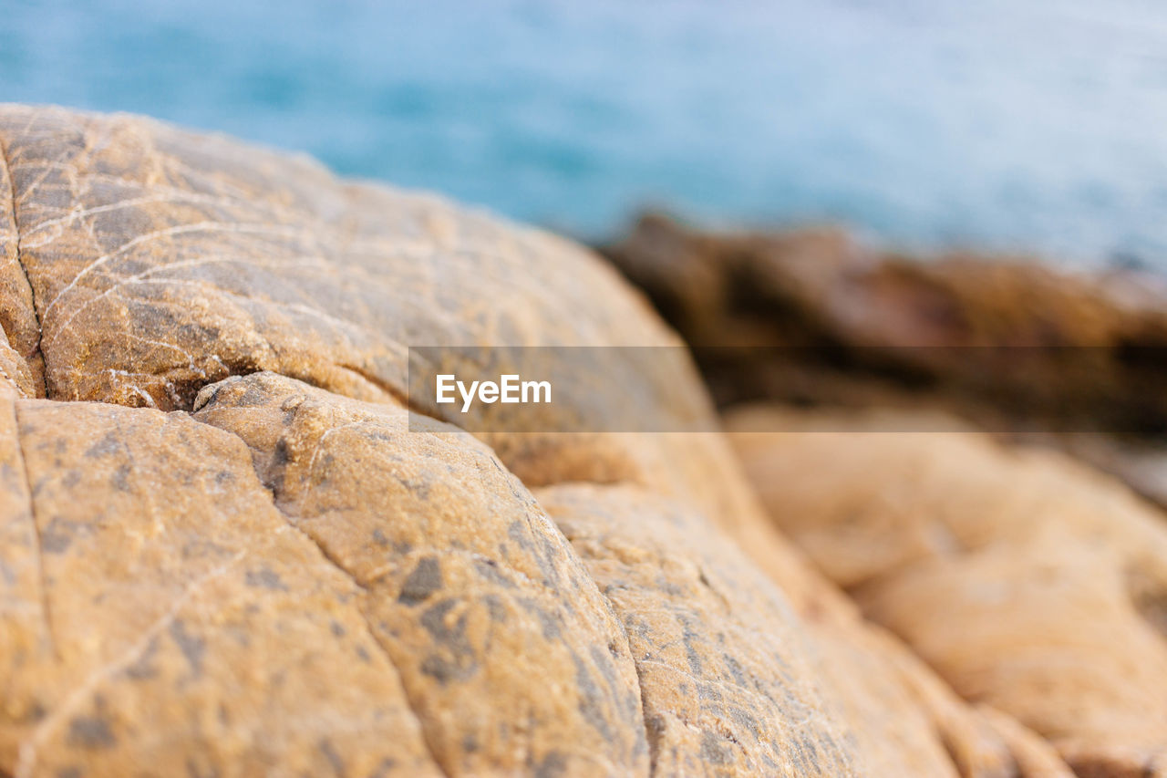 CLOSE-UP OF ROCKS ON BEACH