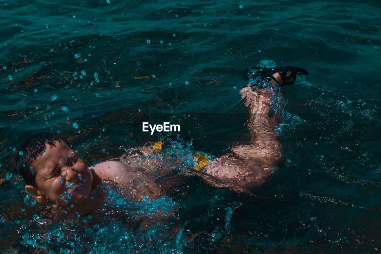 BOY SWIMMING IN SEA