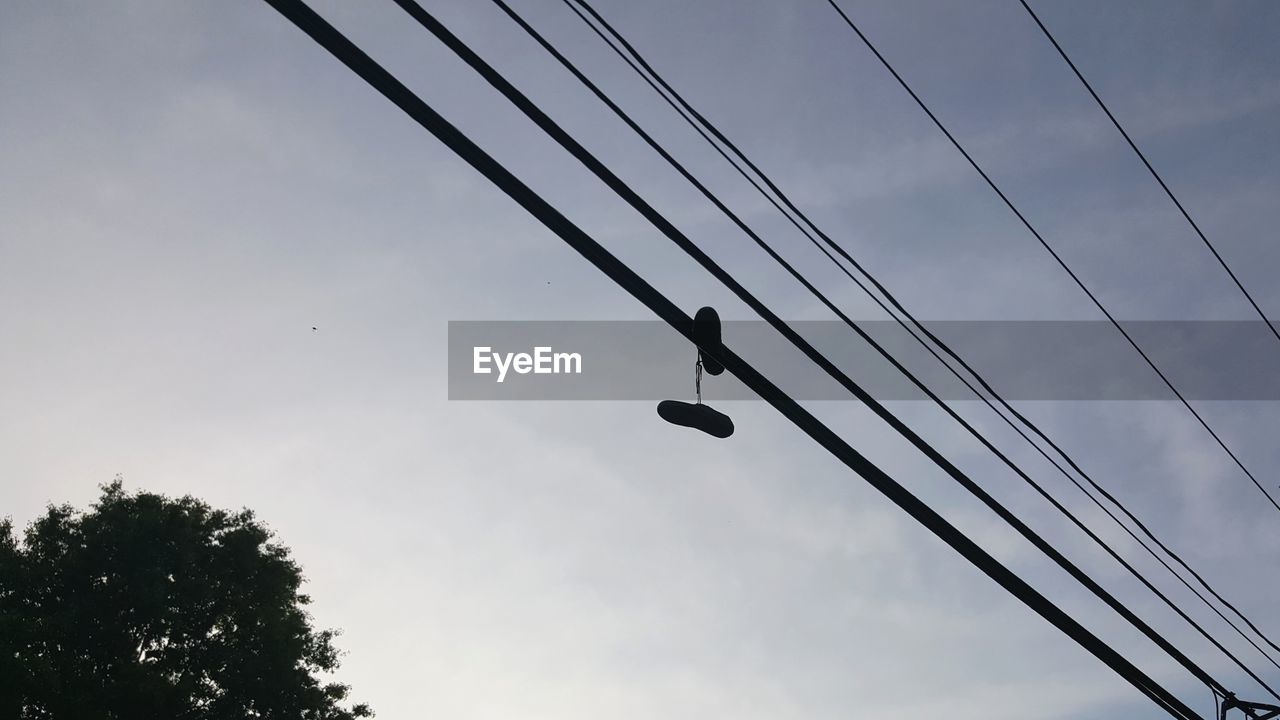 LOW ANGLE VIEW OF BIRDS ON CABLE AGAINST SKY