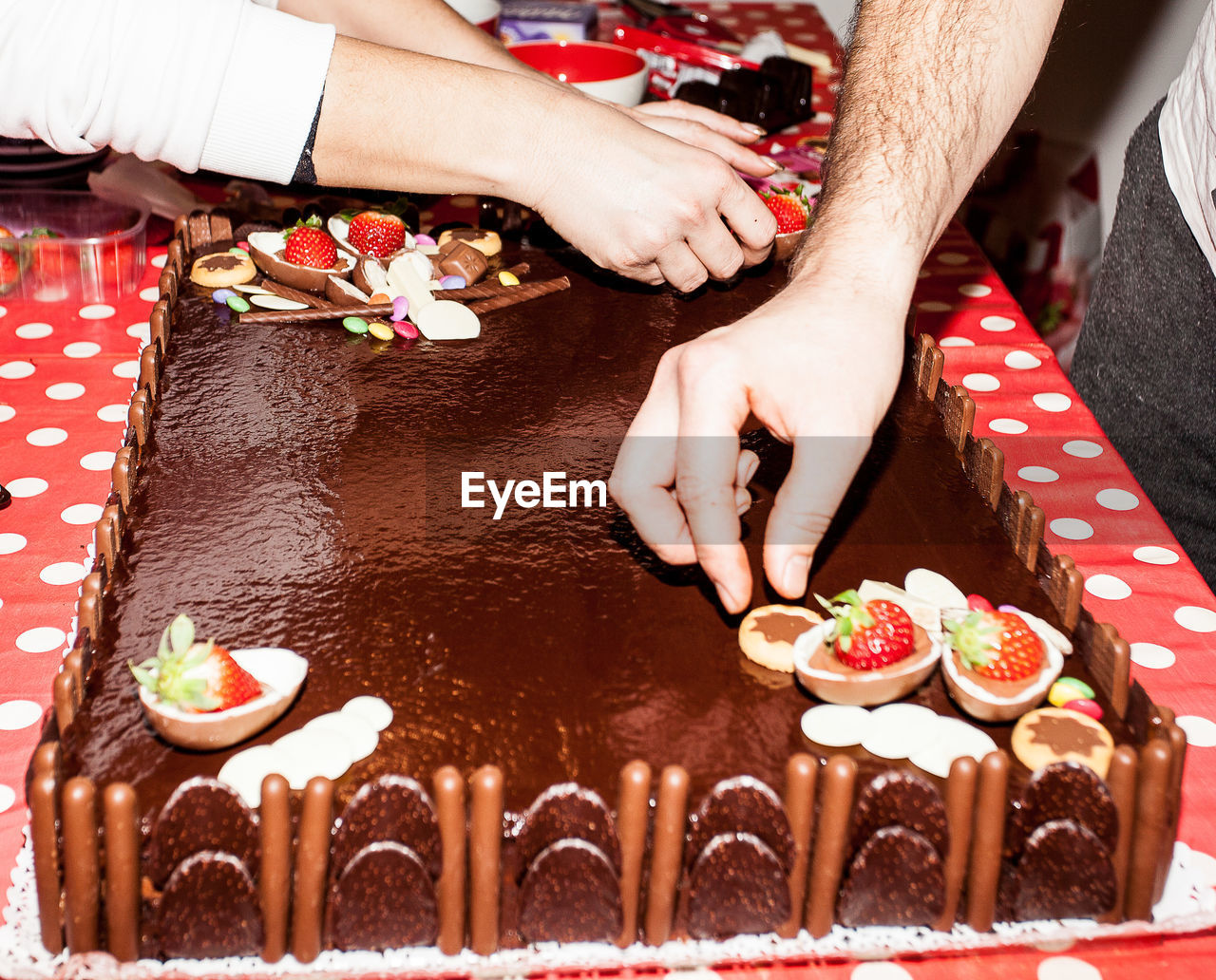HIGH ANGLE VIEW OF PEOPLE PREPARING CAKE
