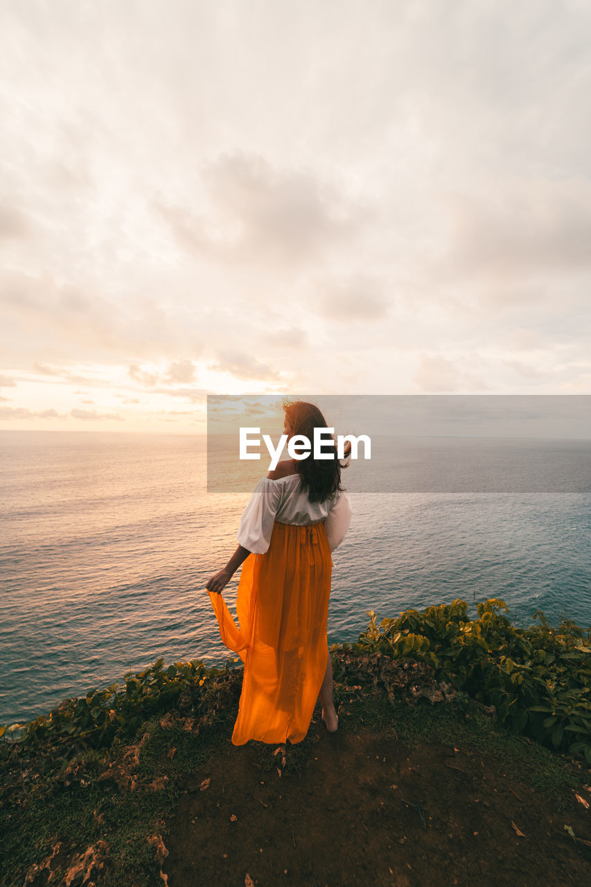 Rear view of woman looking at sea against sky