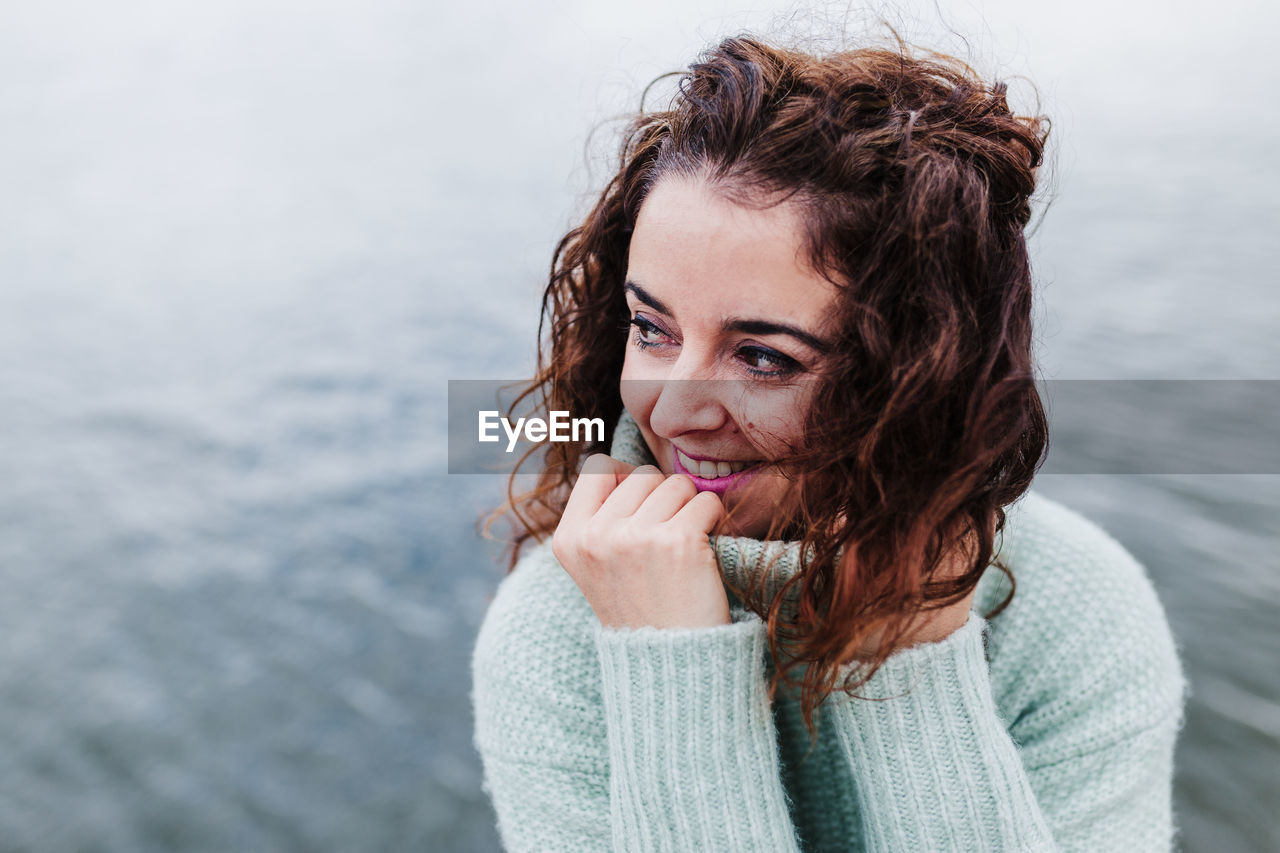 Portrait of woman against sea in background